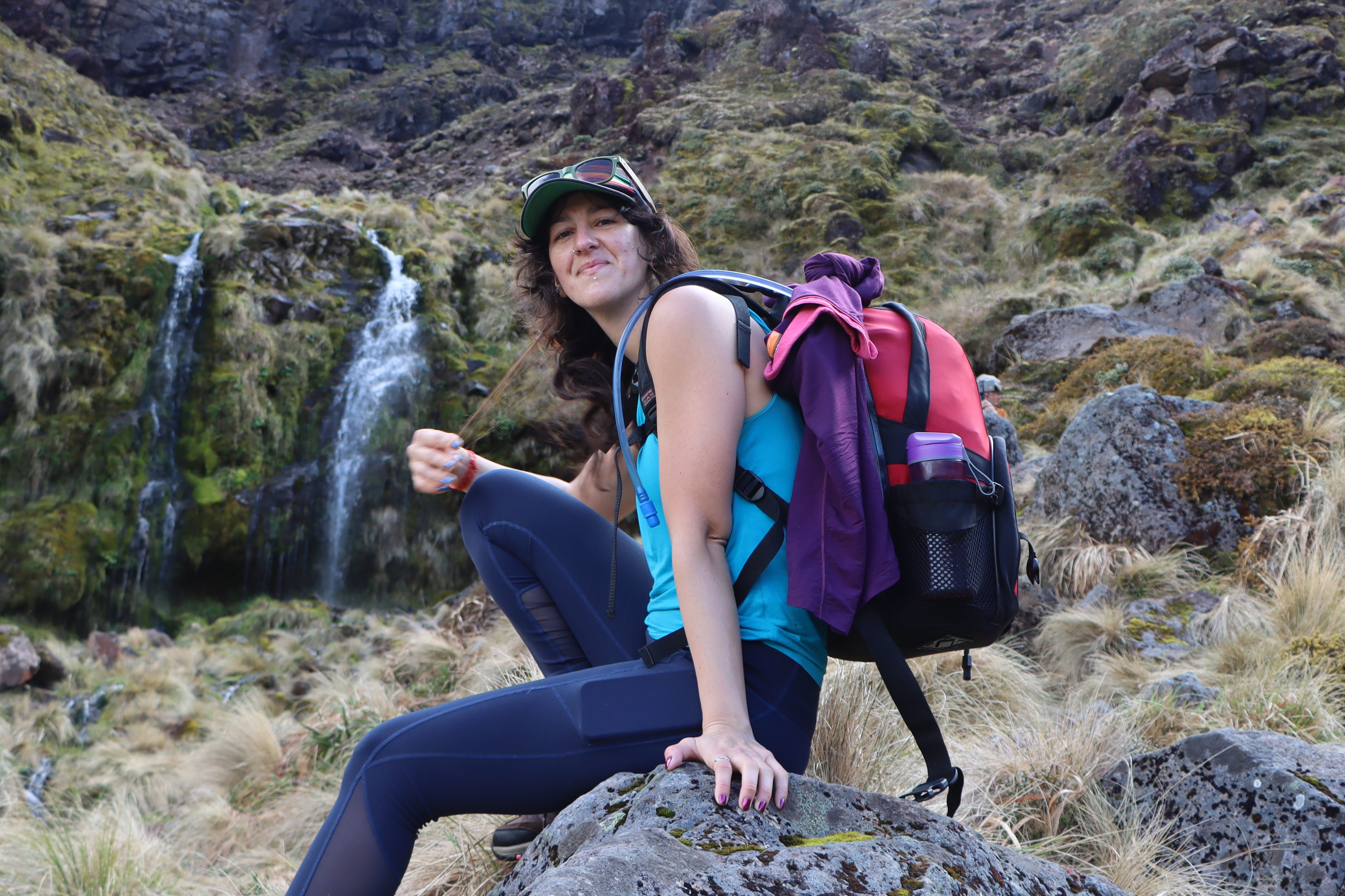 Image of woman with hiking backpack next to waterfall